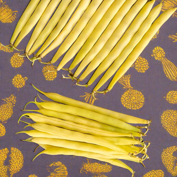 A collection of yellow bean pods laid out on a surface with a patterned background.