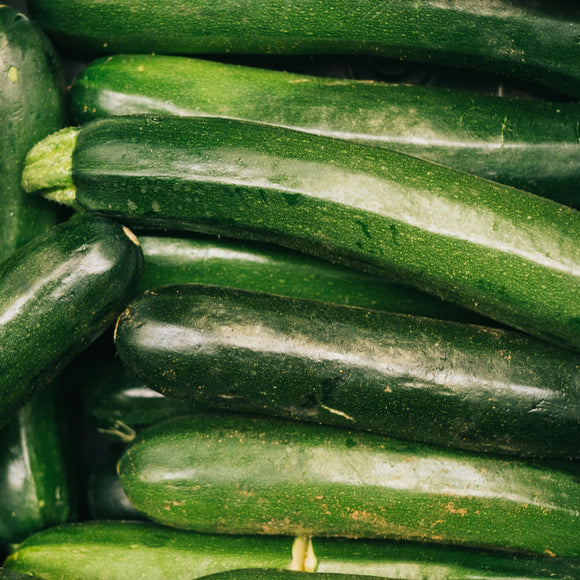 A pile of fresh, dark green zucchini squash.