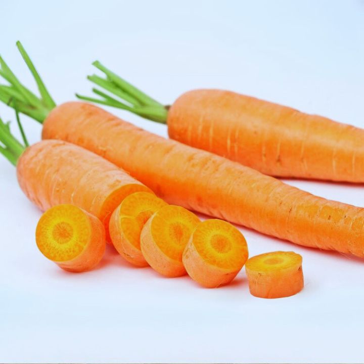 Carrots with green tops on a white background