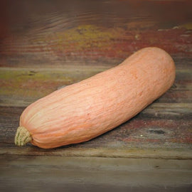 Orange squash on a wooden surface with a rustic background